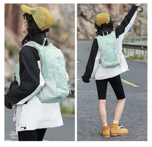 Weibliches Modell trägt einen mintgrünen Wanderrucksack auf einer Außenstraße.