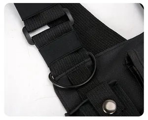 Détail en gros plan des sangles en nylon durable et de l'anneau en D sur un sac de poitrine noir.