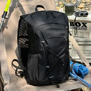 Schwarzer leichter Outdoor-Wanderrucksack mit Gummizügen und Netztaschen auf Campingstuhl.