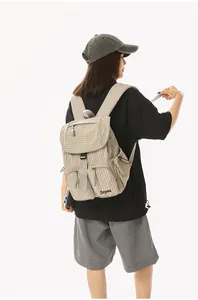 Back view of a woman wearing a light brown checkered nylon backpack for casual use