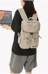 Macro detail of casual checkered nylon backpack worn by a model holding a laptop