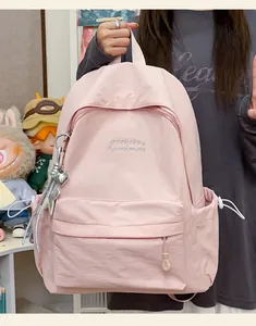 Vista dettagliata dello zaino da studente minimalista rosa con ciondoli e la trama