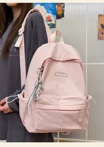 Primo piano di uno zaino rosa chiaro minimalista con ricami e ciondolo a stella