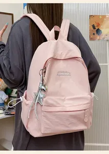 Vista dettagliata di uno zaino casual rosa minimalista in tinta unita con testo ricamato