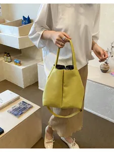 Close-up detail of a bright yellow commuter water bottle bag with crossbody strap