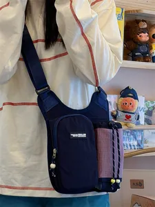 Close-up detail view of a dark blue outdoor sports crossbody bag with water bottle pouch.