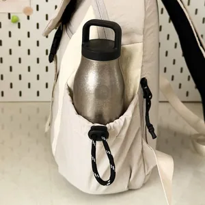 Detailweergave van het zijvak met trekkoord op een lichte waterbestendige kampeerrugzak