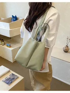Close-up detail of large pale green crossbody water bottle carrier bag for commuters