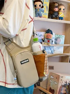 Detail view of a lightweight crossbody bag with a water bottle holder and phone pocket.