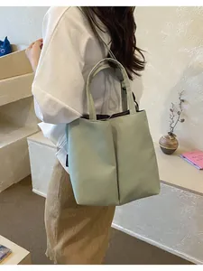 Large light green commuter tote bag with double cup compartments shown being carried