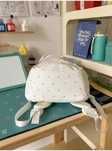 Detailansicht des Bodens und der Riemen eines weißen gepunkteten Schulrucksacks