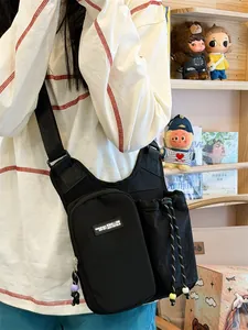 Close-up detail view of black multifunctional outdoor crossbody bag featuring a bottle holder
