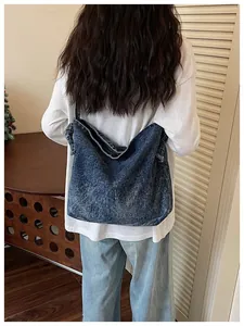 Detailed back view of a vintage blue denim crossbody bag styled with a casual white shirt