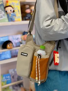 Close-up detail of a khaki crossbody sport sling bag featuring an orange water bottle pocket.