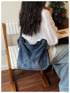 Vintage blue denim crossbody bag shown from the back in a cozy lifestyle scene.