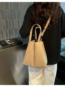 Back view of a khaki large-capacity fabric water bottle carrier bag worn crossbody