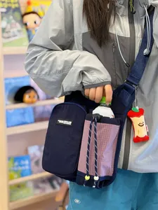 Lifestyle view of a navy blue outdoor sports crossbody bag with water bottle pocket
