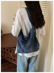 Back view of a model carrying a vintage blue denim messenger bag in a cozy indoor setting