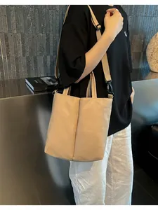 Close-up of minimalist beige commuter tote bag with adjustable shoulder strap