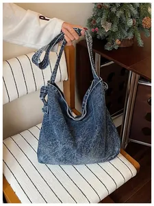 Detail of a vintage denim crossbody bag held by strap on a stylish striped chair