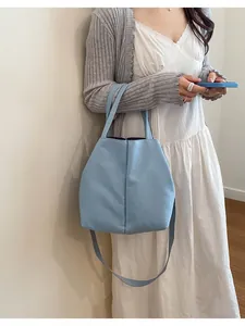 Lifestyle shot of a light blue large crossbody water bottle tote bag for commuting