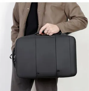 Gedetailleerd overzicht van een professionele zwarte zakelijke laptoptas in de hand gehouden.