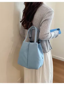 Back view of a model carrying a light blue large capacity commuter water bottle tote bag.