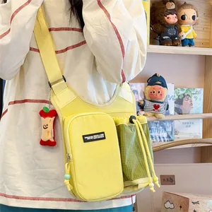 Lifestyle view of yellow crossbody bag with water bottle holder and apple charm