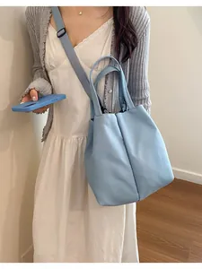 Asian model carrying a large blue water bottle carrier bag with an adjustable strap