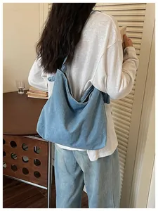 Back view of a casual light blue denim messenger bag for women in a lifestyle setting