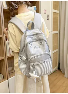 Close-up detail of cute grey preppy style backpack with polka dots and stripes pattern