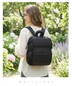 Elegante donna con zaino fasciatoio nero di grande capacità in un giardino