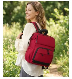 Zaino per pannolini rosso moderno con tasche multiple mostrato in un ambiente esterno