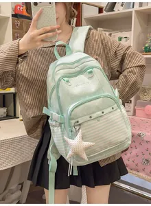 Cute mint green school backpack featuring polka dots, stripes, and a stylish star charm accessory