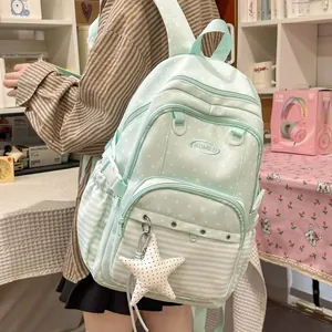 Preppy mint green school backpack with white dots and stripes worn by a student girl