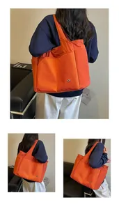 Detailed view of an orange nylon tote bag with multiple pockets and checkered detail.