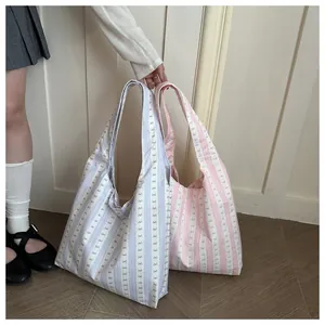 Detailed view of stylish striped canvas tote bags in soft blue and pink with cute bow patterns