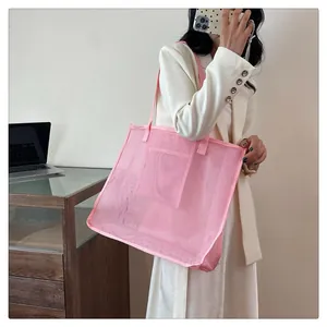 Bolso grande de malla rosa llevado al hombro, ideal para playa o ir de compras.
