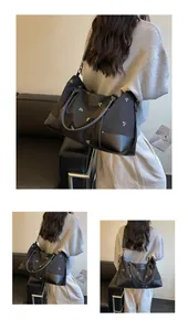 Large black expandable travel bag with floral embroidery shown on model for short trips