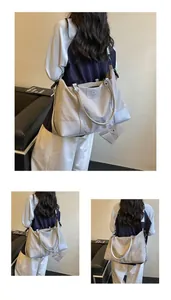 Large capacity expandable travel bag with delicate floral embroidery worn by a model.