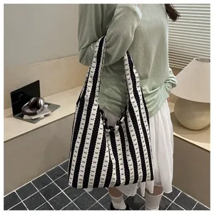 Detail view of a woman wearing a black and white striped tote bag with cute bow patterns