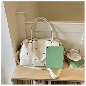 Large capacity floral embroidered travel bag shown with a tablet for size reference