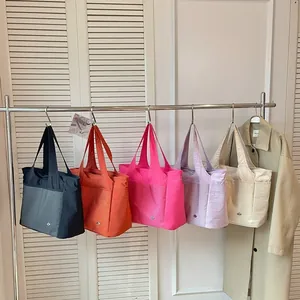 Five colors of large capacity nylon tote bags hanging on a rack for travel and leisure