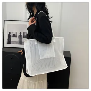 Detalle de un bolso tote grande de malla de nailon blanco para compras y playa por modelo