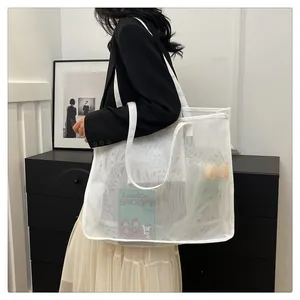 Bolso tote grande de malla de nailon blanco llevado por una modelo en un interior