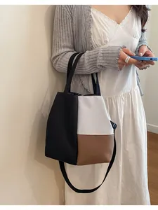 Tricolor color-block tote bag shown being held in a lifestyle daily commuting setting