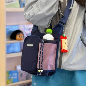 Detail shot of a crossbody sports bag with water bottle compartment worn for hiking.