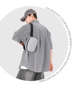 Rückansicht einer grauen Nylon-Umhängetasche mit Karomuster am modischen Modell