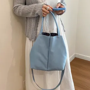 Minimalist light blue large crossbody water bottle tote bag for daily commuting.