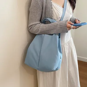 Minimalist light blue crossbody bucket bag designed for water bottles and daily commuting
